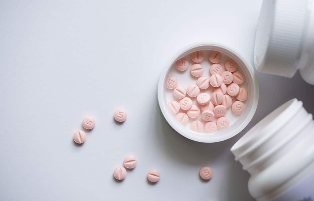 How Is Sublocade Different From Suboxone? A white pill bottle and round pink pills.