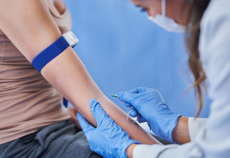 A medical professional finding the vein in a patient's arm