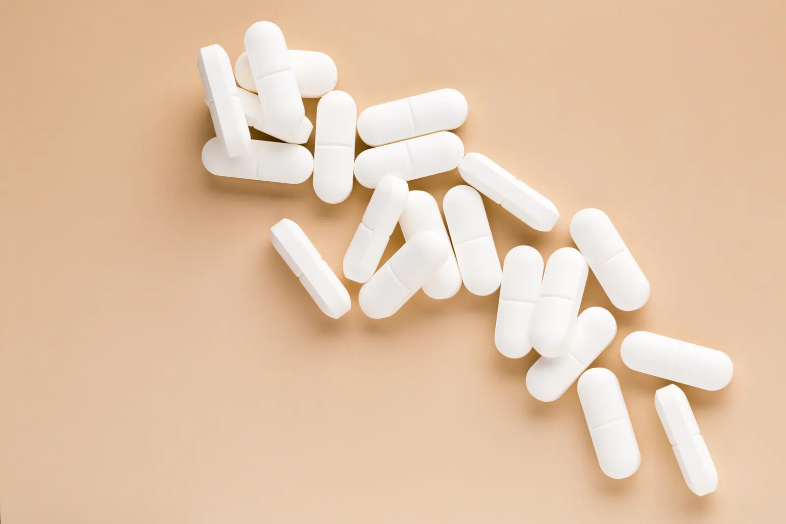 How Long Does Ambien Stay in Your System? White pills on table.